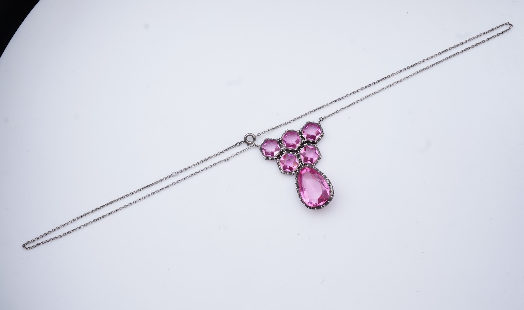 A cut steel brooch, 19th century, and a pink paste pendant